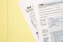 lined paper and W-9 and 1040 tax forms 