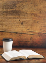 Disposable White Coffee Cup with Black Lid and open Bible 