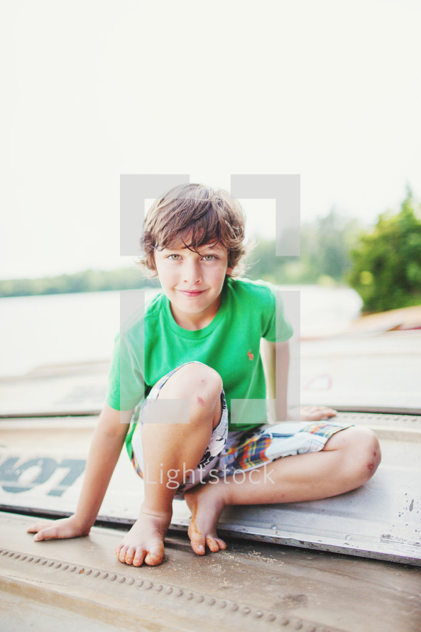 a boy child on an overturned boat 
