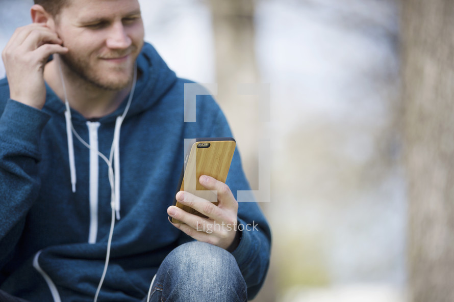 a man listening to a podcast outdoors