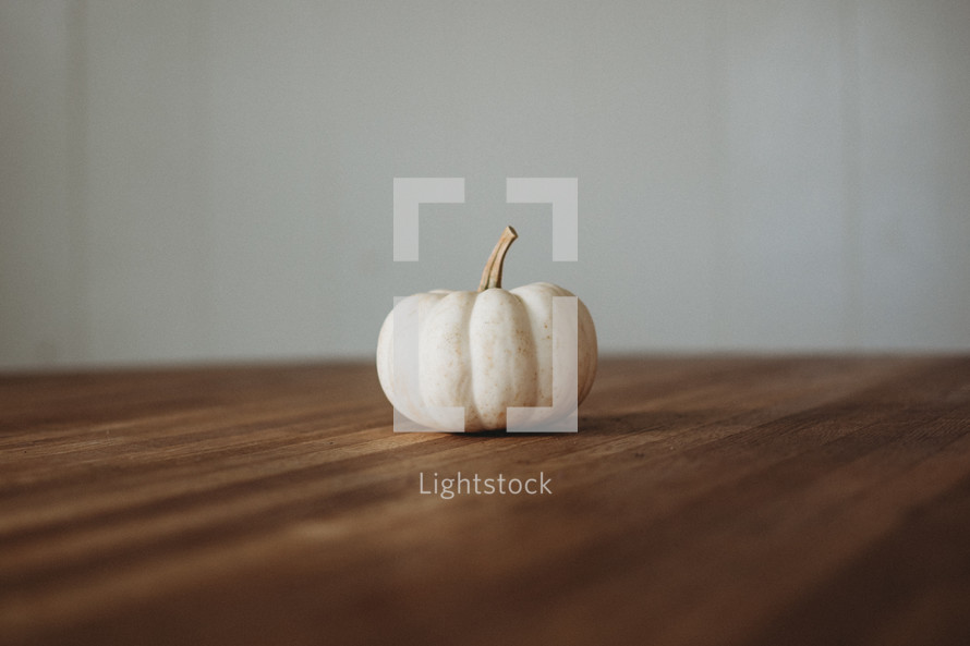 white pumpkin on a wood table 
