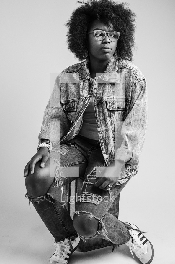 African American young woman with torn jeans and denim jacket 