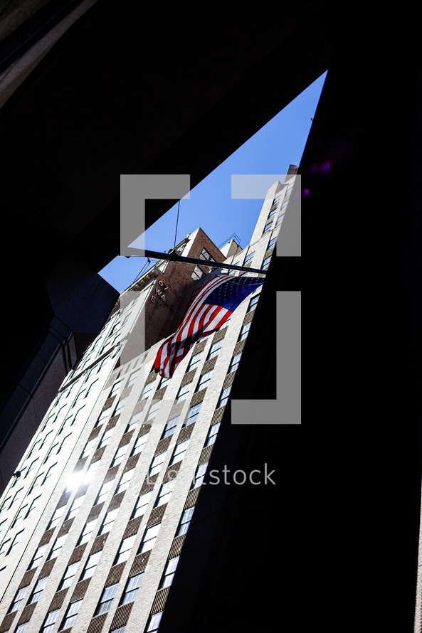 American flag and buildings in a city 