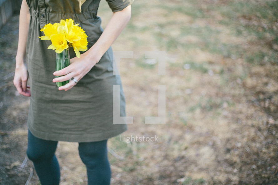 Holding a bouquet of daffodils.