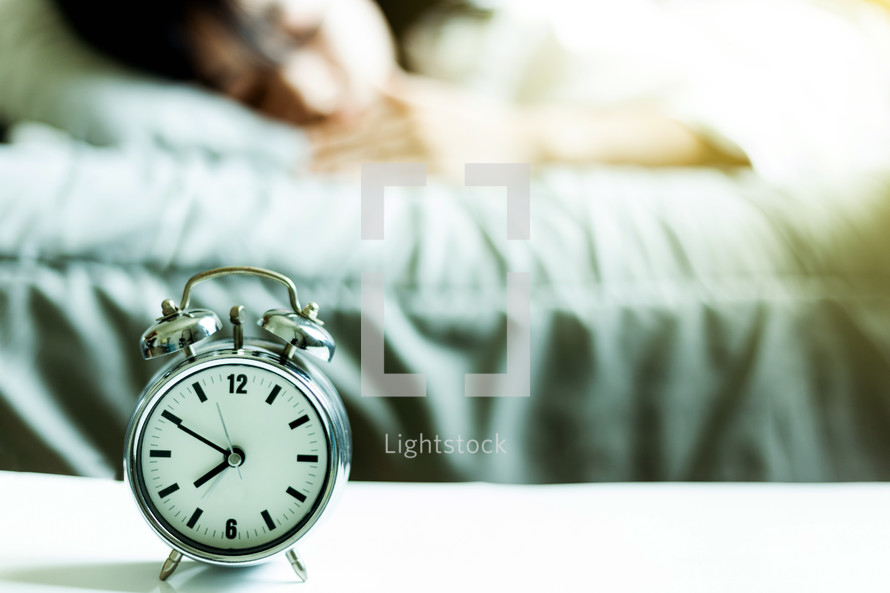 alarm clock and woman sleeping 