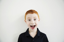 A red haired boy with his mouth wide open.