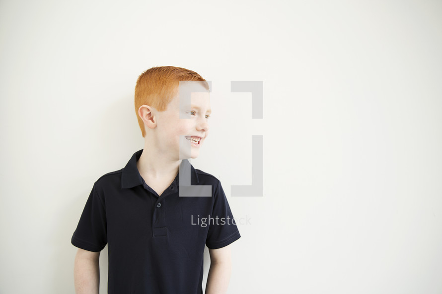 A smiling red-headed boy.