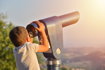 child looking through Tourist telescope eyepiece. Travel tourist destination landscape magnification