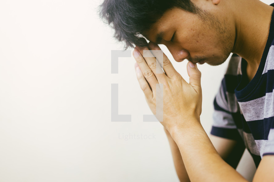 man with head bowed in prayer 