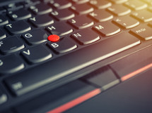 red pointing stick of on a laptop keyboard