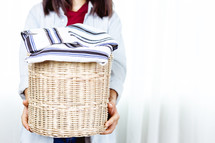 a woman holding a basket of clothes 