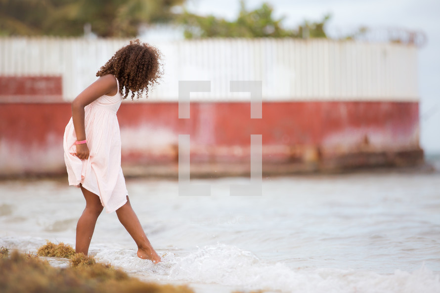 a child tipping her toes in the water 