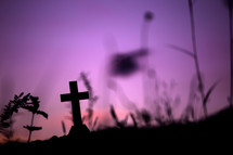 silhouette of a cross against a purple sky