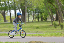 kid boy of 5 years having fun in spring park with a bicycle on beautiful fall day. Active child wearing bike helmet
