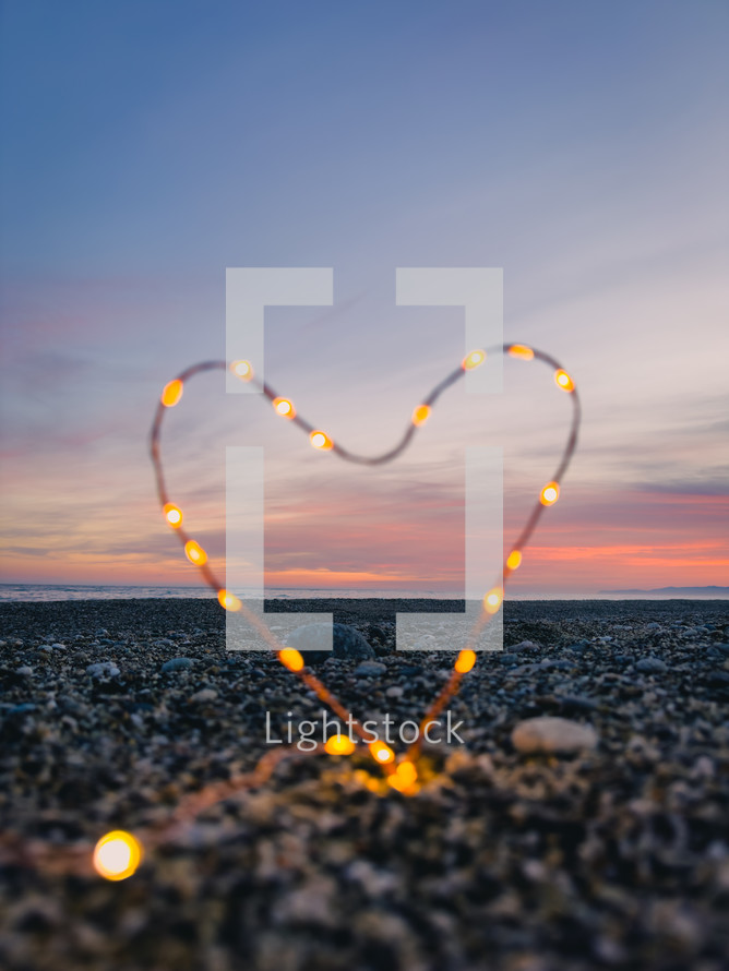 Heart symbol with bright fairy lights on the beach