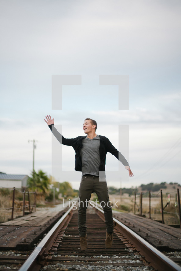 A man standing on railroad tracks. 