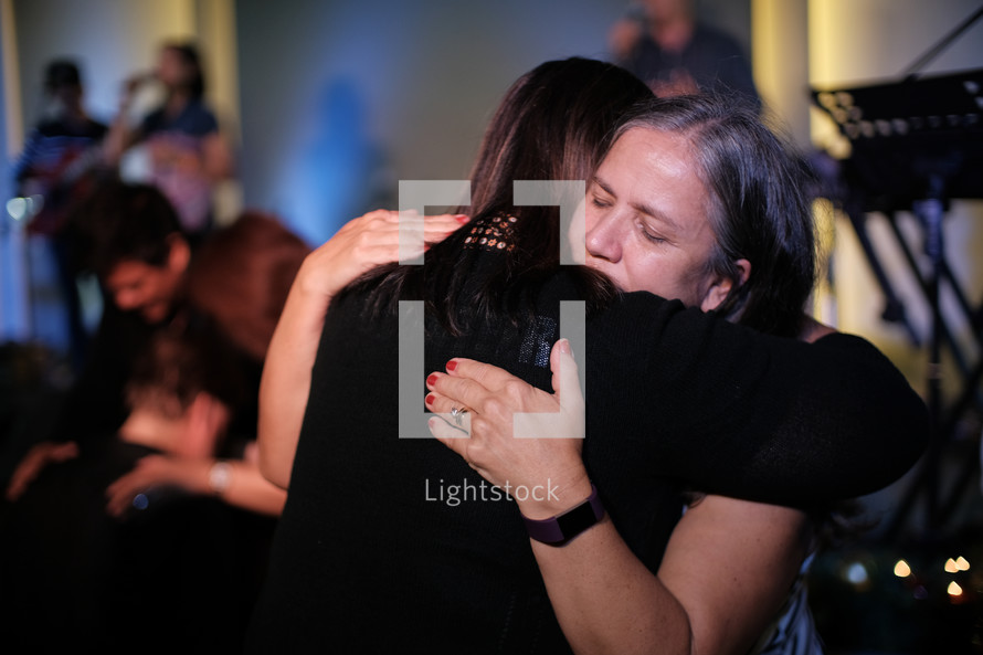 women hugging during a worship service 
