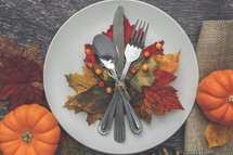 silverware on a plate with fall leaves place setting 