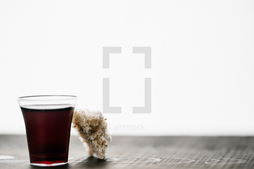 communion wine in a cup and bread on white background 