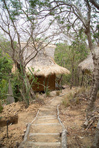 dirt path to cabins with straw roofs 
