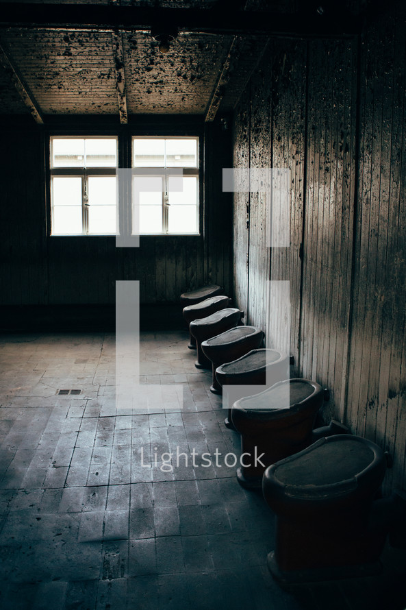 rows of urinals in an old bathroom 