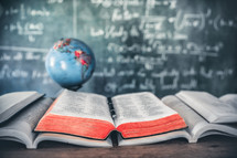 open books and Bibles in front of a chalkboard 