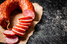 Delicious salami sausage on the table. On a black background. High quality photo