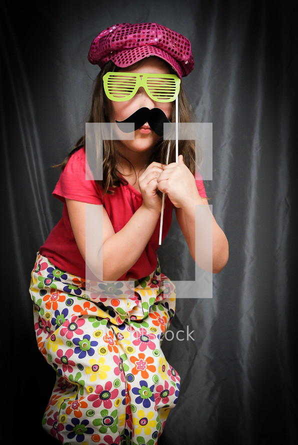 girl child acting silly with sunglasses and a mustache 