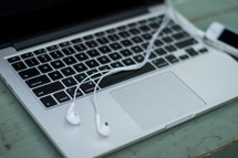 Earbuds on a laptop computer.