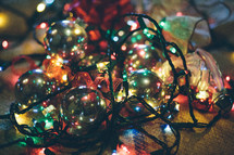 Christmas chaos - pile of ornaments, lights, and ribbon 