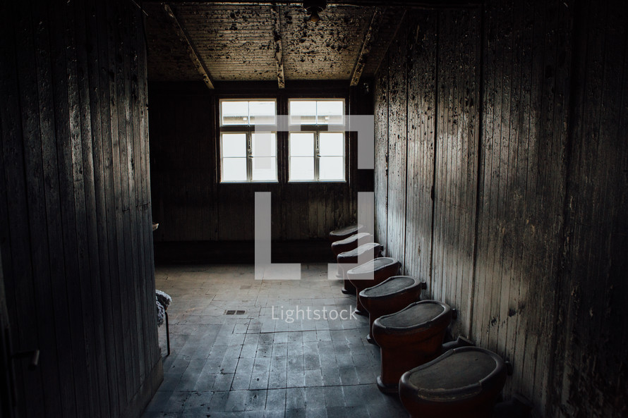 rows of toilets in an old restroom 