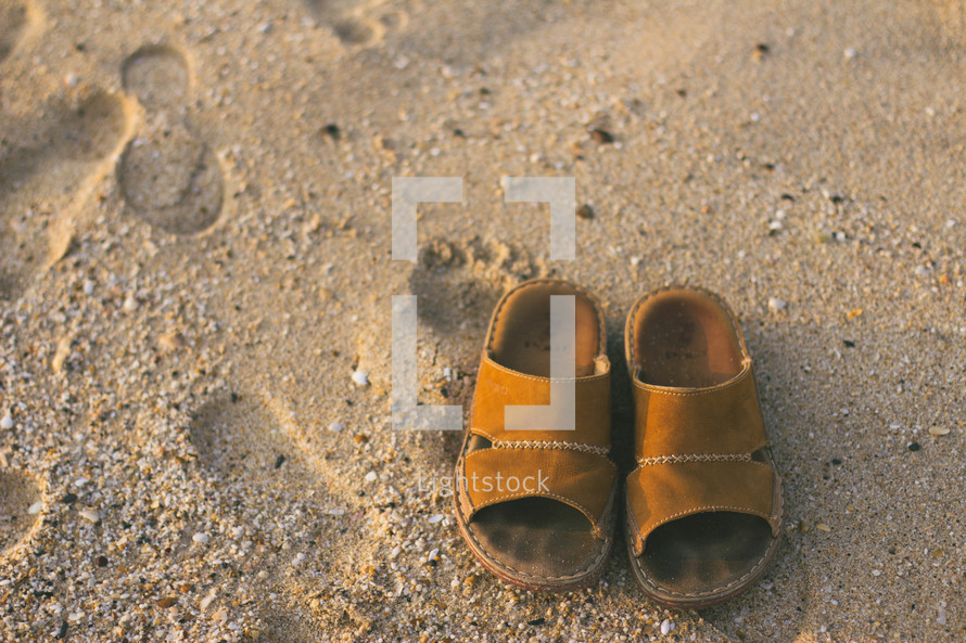 sandals and footprints on a beach 