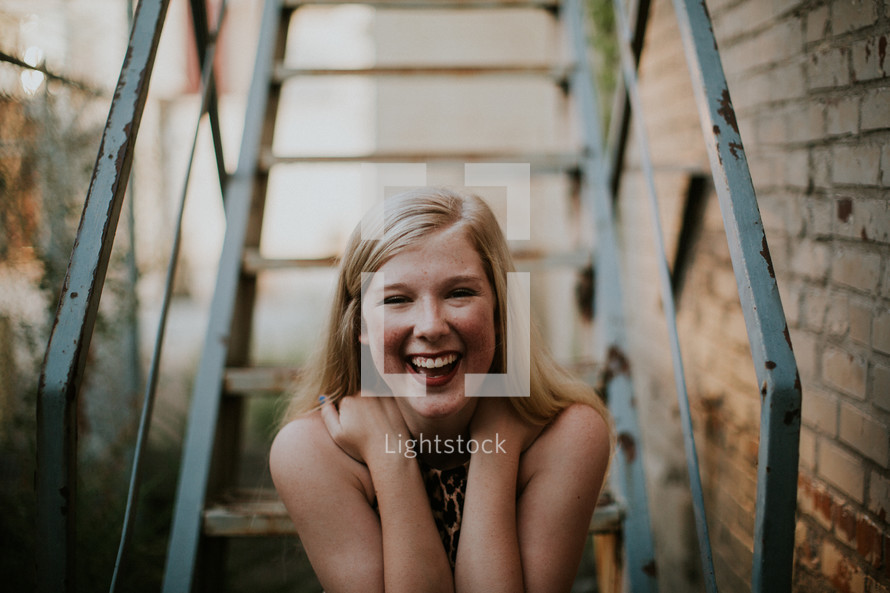 a young woman laughing on steps 