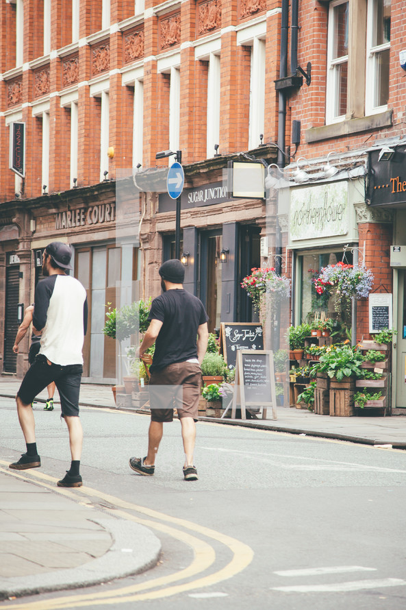 pedestrians walking on a downtown street in front of a flower shop 