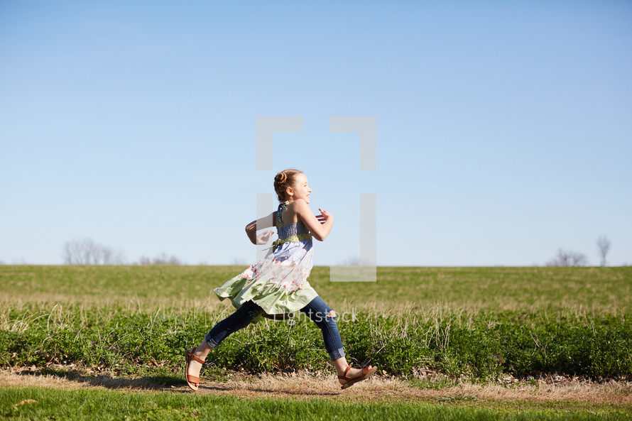 a girl running through a field 