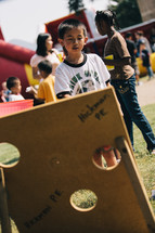 a child playing bean bag toss 