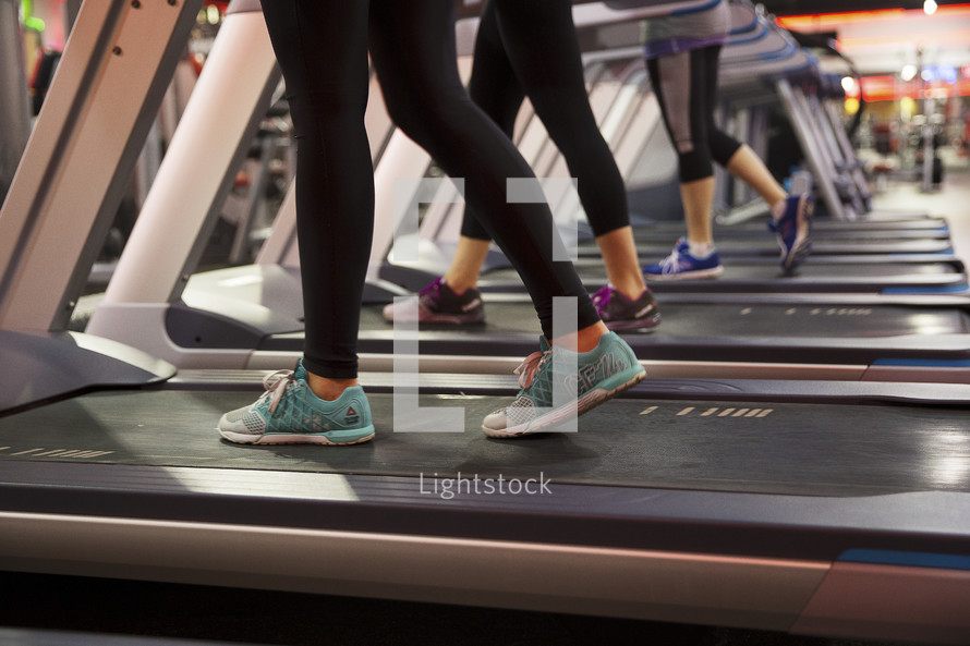 women walking on treadmills at the gym.