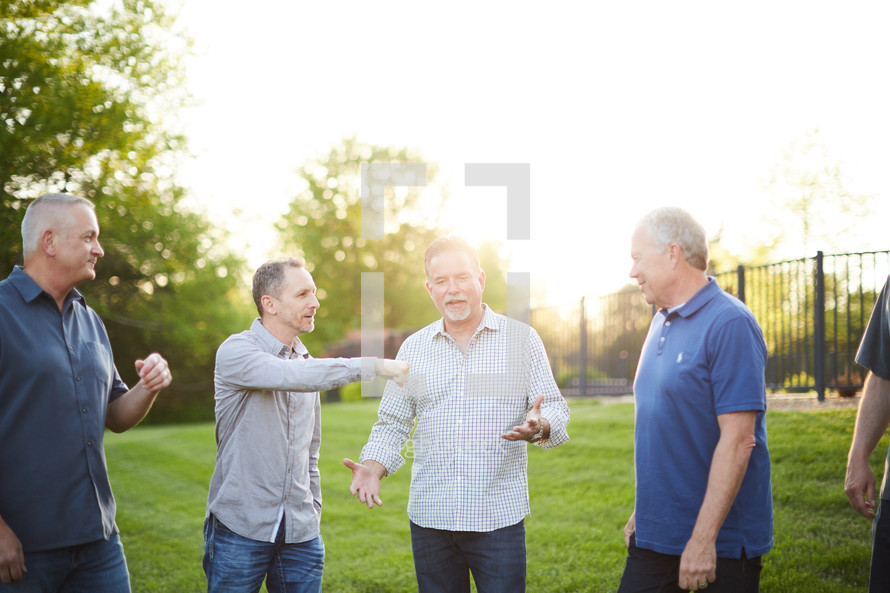 men standing in a backyard talking 
