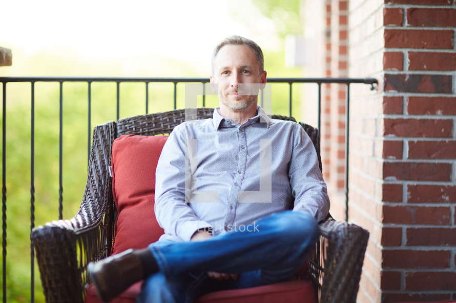 a man sitting on a porch relaxing 