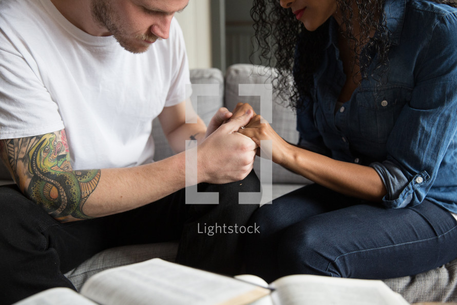 a couple reading a Bible and praying together 