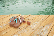 flip flops and sunglasses on a wood dock 