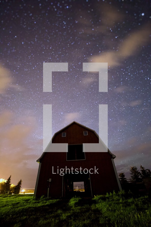 barn under stars in the night sky 
