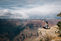 woman sitting at the edge of a Canyon landscape 