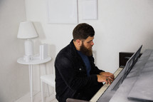 man playing a piano in a white room 