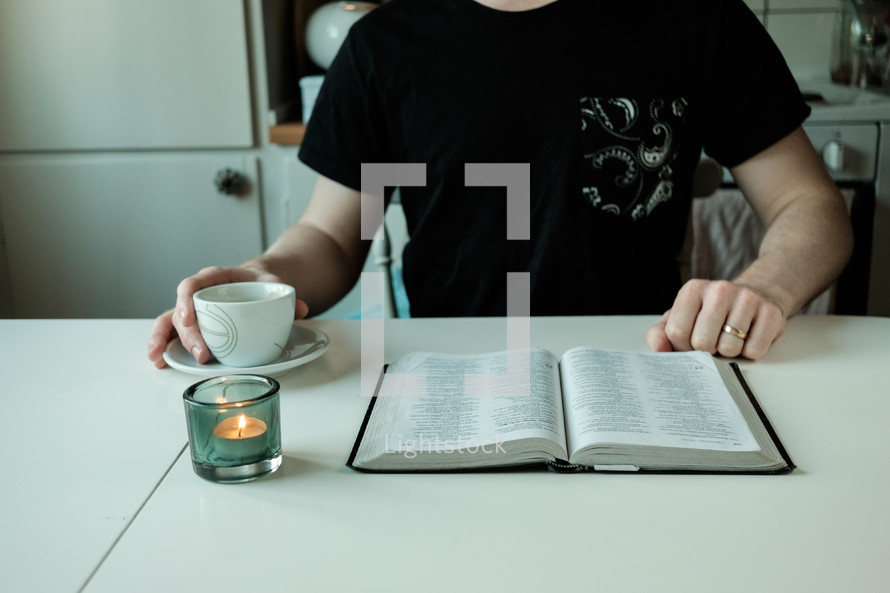 a man with a tea cup and open Bible 