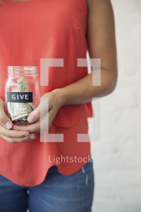 woman holding a give money jar 