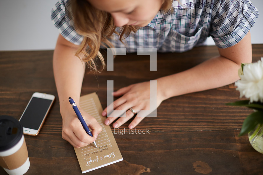 a woman taking notes on a notepad 