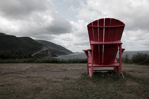 red Adirondack chair on a beach 