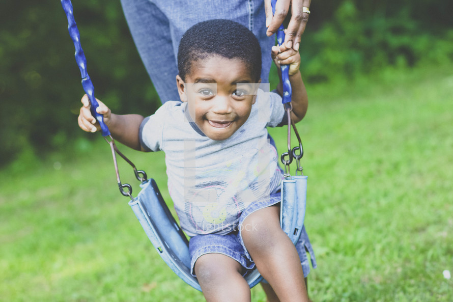toddler boy on a swing 