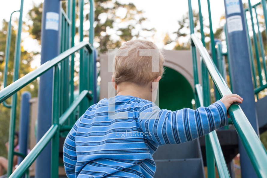 a toddler boy on playground equipment 